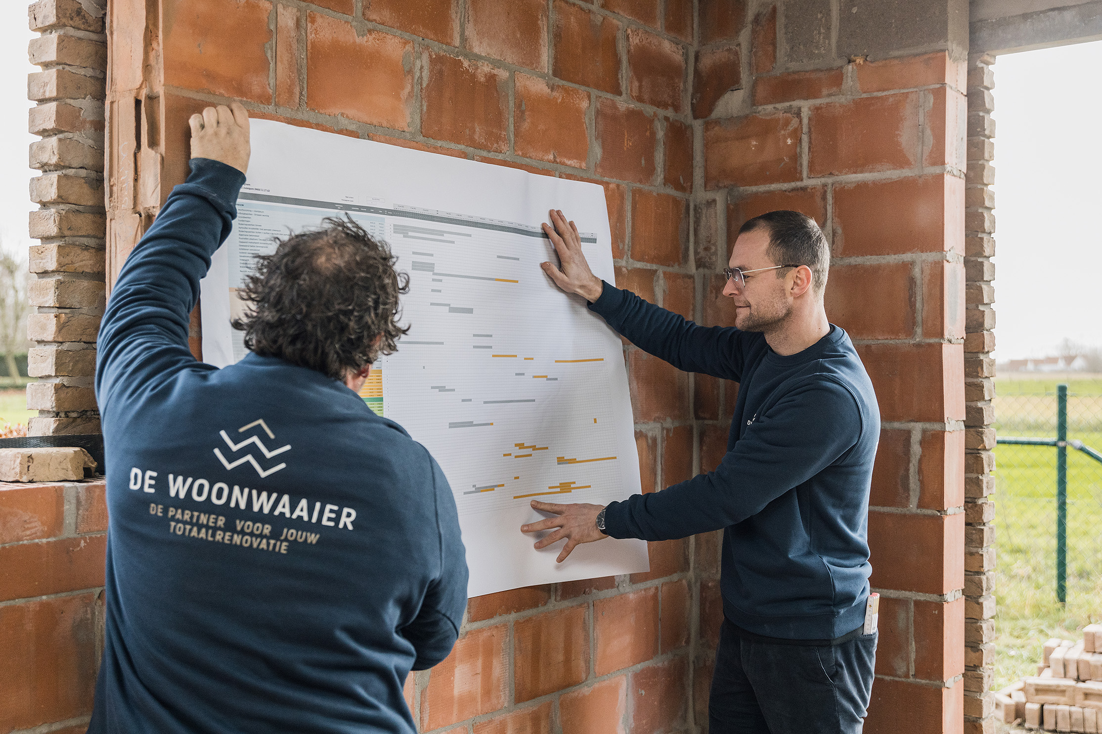 Twee medewerkers volgen de planning van ruwbouwwerken op.